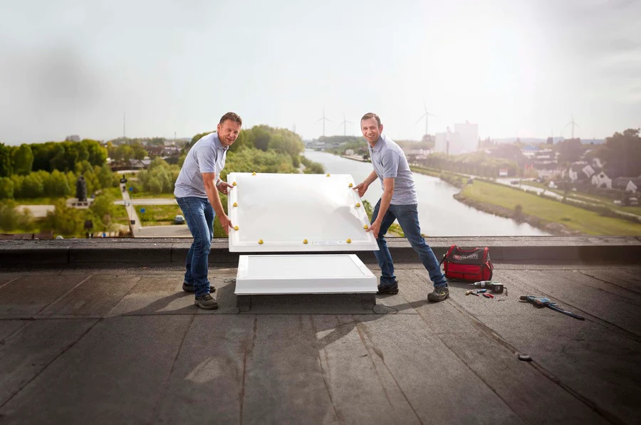 Mannen die een lichtkoepel vervangen op het dak